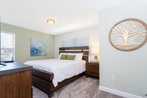 a bedroom with a bed and a mirror on the wall at Gorgeous 5 Bd w/ Pool Close to Disney @ Champions Gate 948 in Kissimmee
