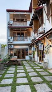 a building with a courtyard with grass in front of it at P&B Residences Legazpi in Legazpi