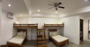 a room with three bunk beds and a ceiling fan at P&B Residences Legazpi in Legazpi