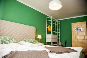 a green bedroom with a bed and a green wall at Gut Boltenhof in Fürstenberg