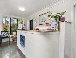 a white room with a counter with plants on it at Cooks Endeavour Motor Inn in Tweed Heads