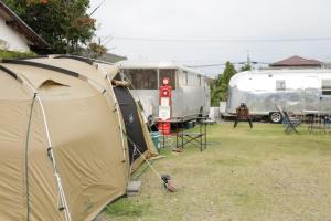 a tent and two rvs parked in a field at Guest House Uminokyojyusya - Vacation STAY 04260v in Miyazaki +2 photos