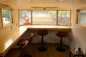 a tiny house with two chairs and a bar at Guest House Uminokyojyusya - Vacation STAY 04260v in Miyazaki