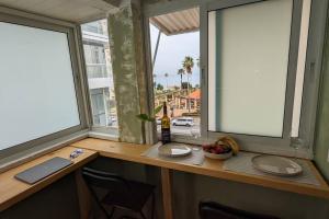 a counter with two windows and a bottle of wine at By the sea in Netanya