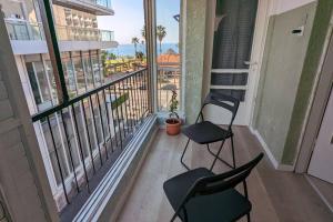 two chairs on a balcony with a view of the ocean at By the sea in Netanya