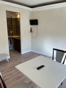 a room with a white table with a remote control on it at Attrap'R&ecirc;ves in Aspres-sur-Bu&euml;ch