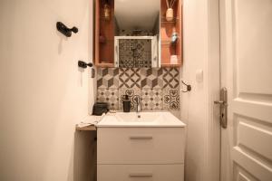 a small bathroom with a sink and a mirror at Gîte Cosy Green avec Jardin, espace vintage et jeux de société in Chevincourt +99 photos