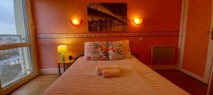 1 dormitorio con 1 cama grande y paredes de color naranja en Cap Sud - 53m2- VUE PYRENEES- HYPERCENTRE-Parking -WIFI FIBRE, en Tarbes