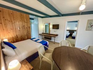 a bedroom with a bed and a table in a room at Snow Season Motor Inn in Cooma