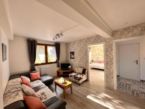 a living room with a couch and a chair at Le Caprice de Beaulieu in Beaulieu-sur-Dordogne