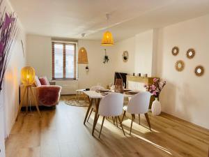 a living room with a dining room table and chairs at Le bohème in Noisseville