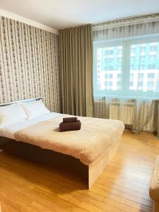 a bedroom with a large bed in front of a window at Книжный Город in Almaty