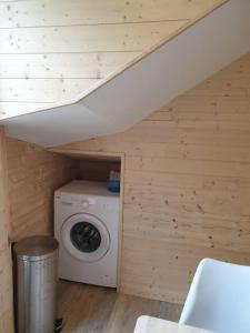 a washer and dryer in a wooden room with a staircase at Les Iris Véranda Parcking in Le Mont-Dore