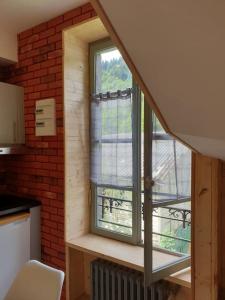 a small kitchen with a window in a house at Les Iris Véranda Parcking in Le Mont-Dore