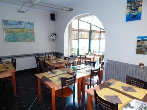 a dining room with wooden tables and chairs at Albergo Torino in Albenga