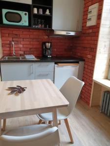 a kitchen with a table and two chairs and a counter at Les Iris Véranda Parcking in Le Mont-Dore