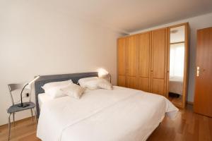 a bedroom with a large white bed with a lamp at Apartment Ajdi in Ajdovščina