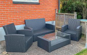 tres sillas de mimbre y una mesa frente a una pared de ladrillo en Gorgeous Home In Visby With Sauna, en Visby