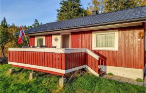 una casa roja con porche y bandera en Pet Friendly Home In Evje With Wifi en Evje