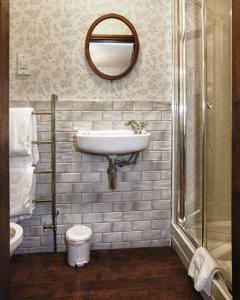 ein Bad mit einem Waschbecken und einem Spiegel in der Unterkunft Hodgkinsons Hotel Matlock Bath in Matlock