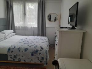 a bedroom with a bed and a television on a dresser at Room in Camden with Queen Size Bed for Non Smoking Females only in London