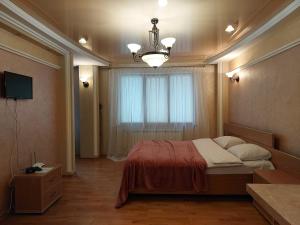 een slaapkamer met een groot bed en een raam bij Затишна студія біля центру in Loetsk