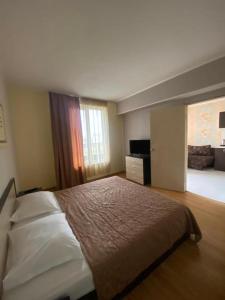 a bedroom with a large bed and a window at Apartments Devora 1 & bar & restaurant in Varna City