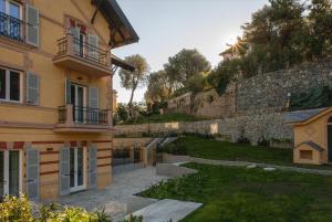 un bâtiment à côté d'un mur avec une cour dans l'établissement Residence Via Di Francia, à Arenzano