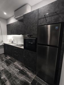 cocina con nevera de acero inoxidable y fregadero en Chalkida Hilltop Apartments en Chalkida