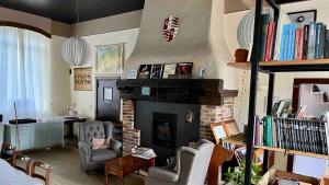 - un salon avec une cheminée, deux chaises et un bureau dans l'établissement B&B Les Ecoliers, à Gouvy