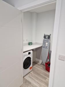 a kitchen with a washer and dryer in a room at Luxury 3 Bed House, Parking, Garden and 2 Office desks 2 in Southbourne