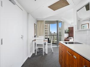 a kitchen with white walls and a table and chairs at LEGENDS HOTEL - hosted by Coastal Letting in Gold Coast