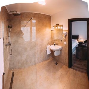 a bathroom with a glass shower and a sink at Motel Piatra Corbului in Bicaz