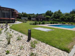 a garden with a swimming pool and a gravel yard at Vila Plana nad Luznici in Planá nad Lužnicí