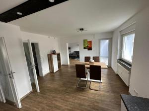 een lege woonkamer met een tafel en stoelen bij Casa Ideal in Bruchsal