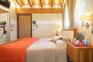 una camera da letto con un grande letto con una coperta arancione di B&B Ambrosia ad Aosta