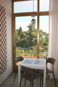 comedor con mesa, sillas y ventana en Il Balcone di Galatea, en Acireale