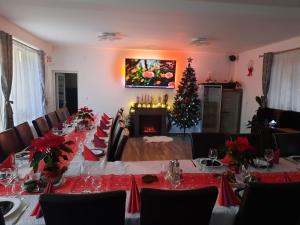 a dining room with a table and a christmas tree at Casa Hărșan in Sovata