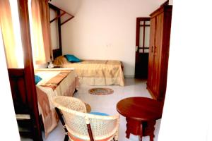 a room with two beds and a table and chairs at Mango Tree House in Beruwala