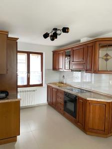 een keuken met houten kasten en een fornuis met oven bij Apartma Bubi in Bovec