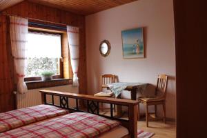 a bedroom with a bed and a table and a window at Komfort-Ferienwohnung-BURCK-97-qm-3-Schlafzimmer-2-WC in Wankendorf