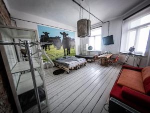 a living room with a painting of cows on the wall at Loft Sen Pszczoły in Warsaw