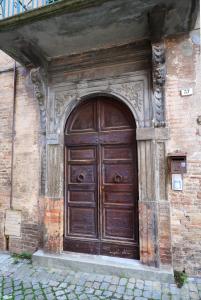 una gran puerta de madera en el lateral de un edificio en BIBO'S GUESTHOUSE, en SantʼAngelo in Vado