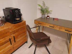 a desk with a chair next to a desk with a microwave at Motyl Noclegi Bytom in Bytom