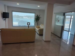 salon z kanapą i dużym oknem w obiekcie Hotel Brisa del Mar w mieście O Grove