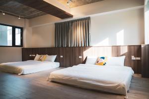 1 dormitorio con 2 camas en una habitación en Flower Garden B&B, en Hengchun