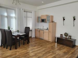 a kitchen and dining room with a table and chairs at Das Nest Boardinghouse Hamburg Niendorf in Hamburg