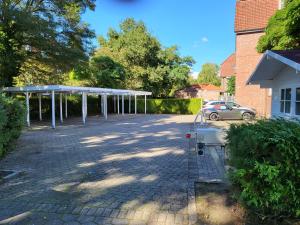 un estacionamiento con un dosel y un coche en Das Nest Boardinghouse Hamburg Niendorf en Hamburgo