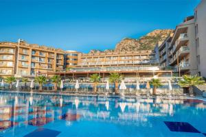 a hotel with a swimming pool in front of a building at Turunc Premium Hotel in Turunç