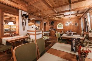 a dining room with wooden ceilings and tables and chairs at Hotel Piz Buin in Ischgl